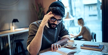 Male student researching his dissertation proposal