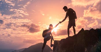 Climbers helping each other on a mountain